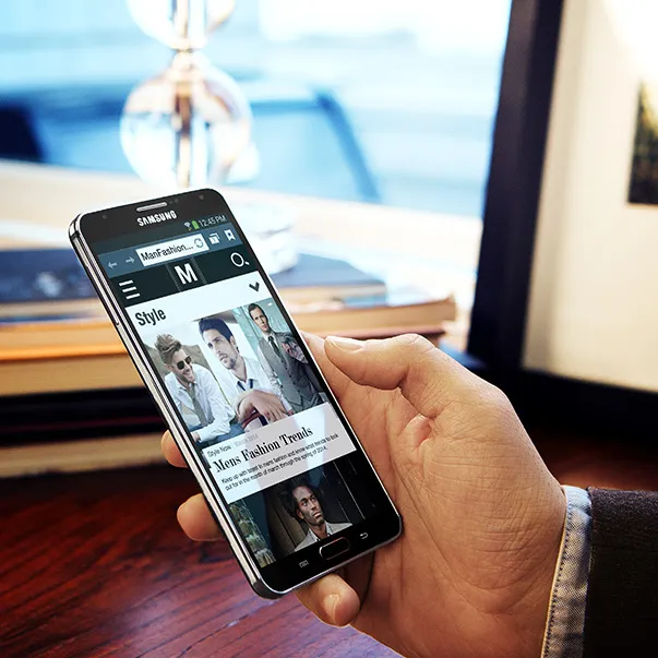 Galaxy Note in hand showing a men’s fashion article